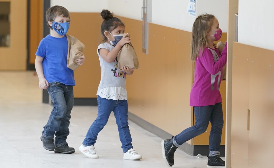 Students carry sack lunches at Elk Ridge Elementary School in Buckley, Wash. On Monday, USDA unveiled a new program that would feed millions of children over the summer, when many schools are closed.