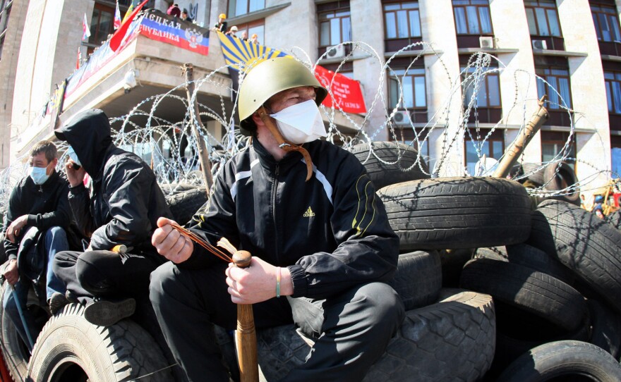 A pro-Russian militant holding a bat guards a barricade in front of the Donetsk Regional Administration building on Tuesday.