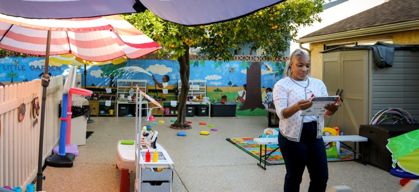 During the early morning, Tonya Muhammad walks through the playground of her child care in Hawthorne, making last inspections before children arrive on Oct. 28, 2021.