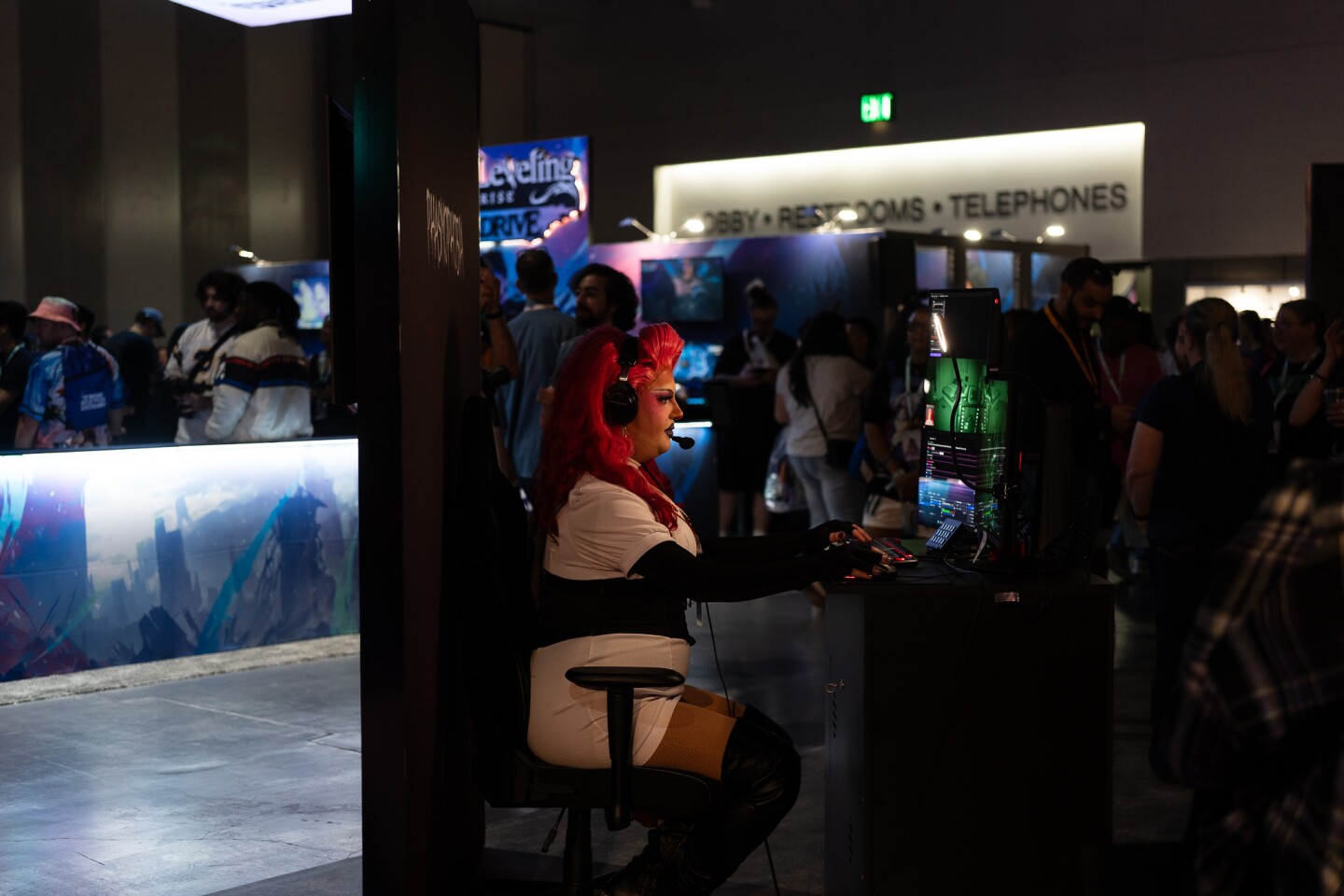 A drag performer and streamer plays a video game on the TwitchCon exhibit floor at the San Diego Convention Center on Oct. 17, 2025.