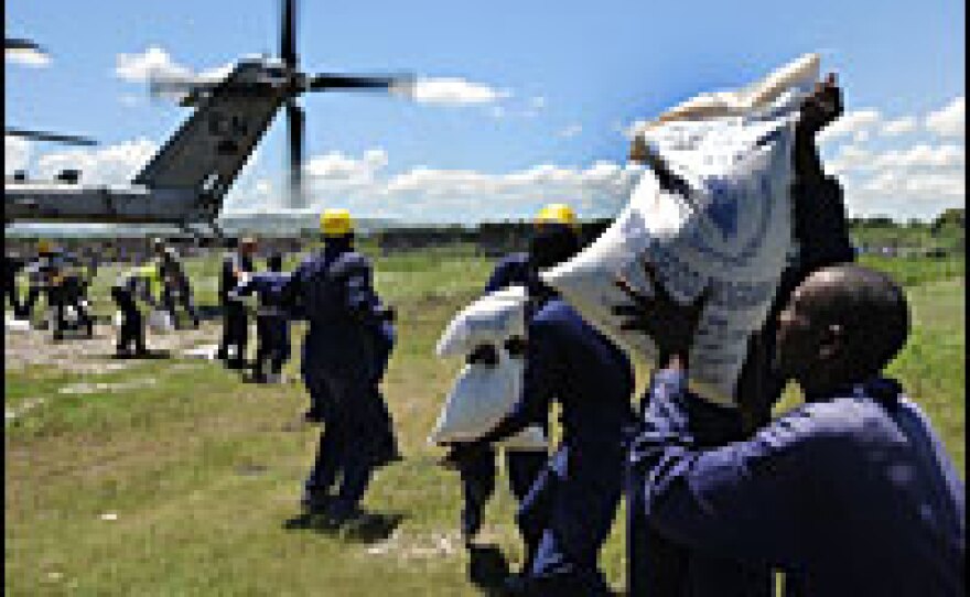 Haitians unload supplies donated by Canada from a U.S. military helicopter in Port De Paix on Thursday.