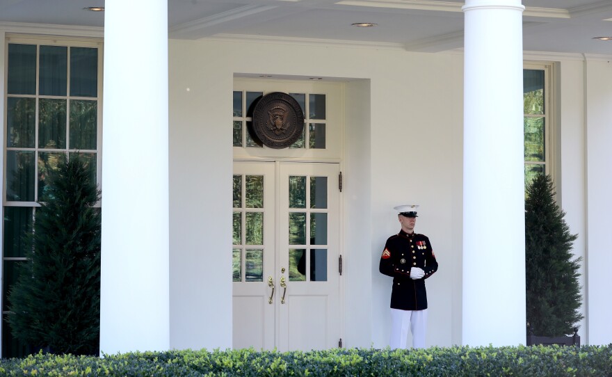 A U.S. Marine stands watch outside the doors of the White House West Wing on Wednesday. According to the White House, President Trump was in the Oval Office Wednesday afternoon, even as he continues to be monitored for COVID-19.