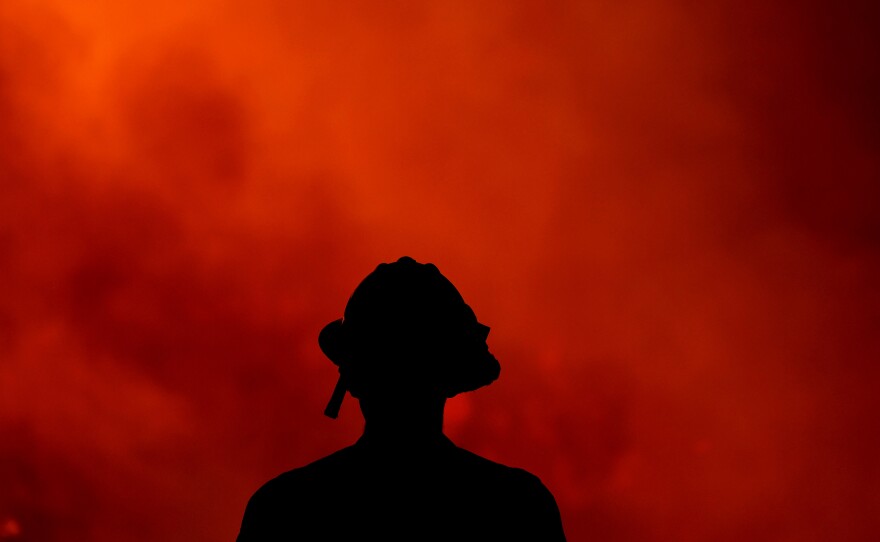 A firefighter keeps watch Thursday on the Holy Fire, which has ravaged the Cleveland National Forest in Lake Elsinore, Calif. Authorities say they believe Forrest Gordon Clark, 51, is the arsonist who set the forest ablaze.