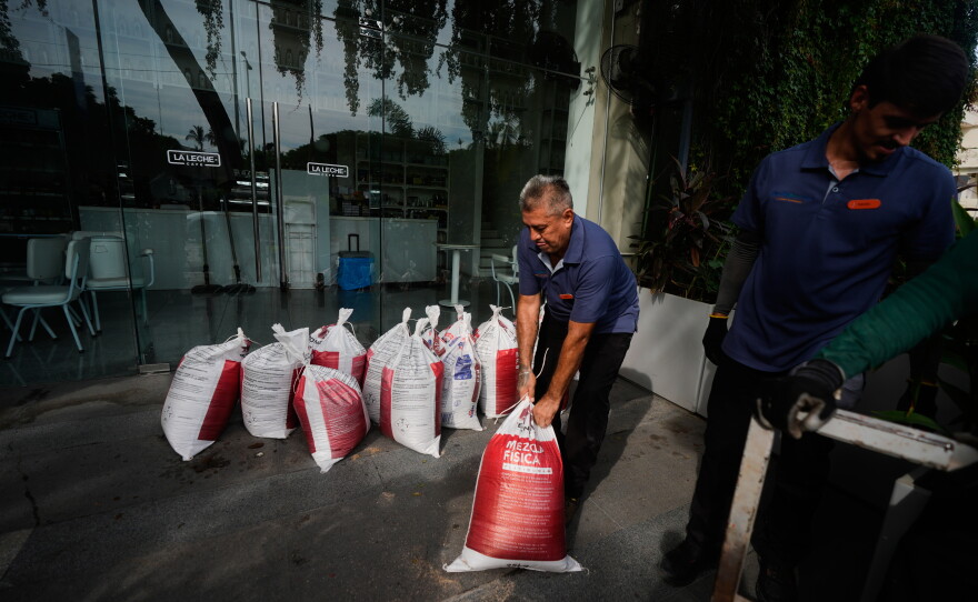 Workers place sandbags outside a restaurant as Hurricane Simon approaches Puerto Vallarta, Mexico, Saturday, Oct. 10, 2026.