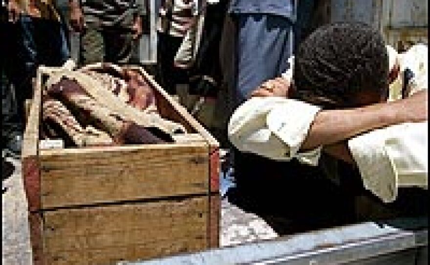 An Iraqi mourns near a coffin of a relative during a funeral procession in Baqouba.
