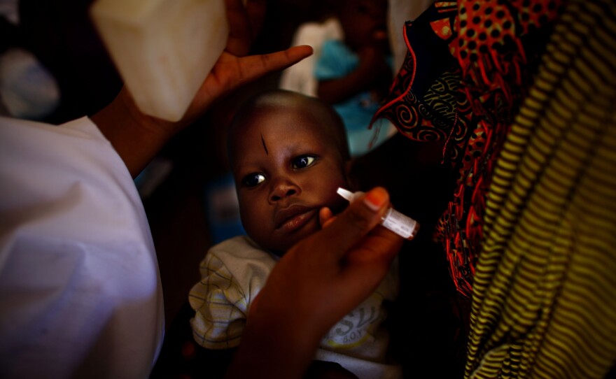 At the health clinic in Minjibir, two drops of vaccine are dropped into a child's mouth during a 2012 campaign.