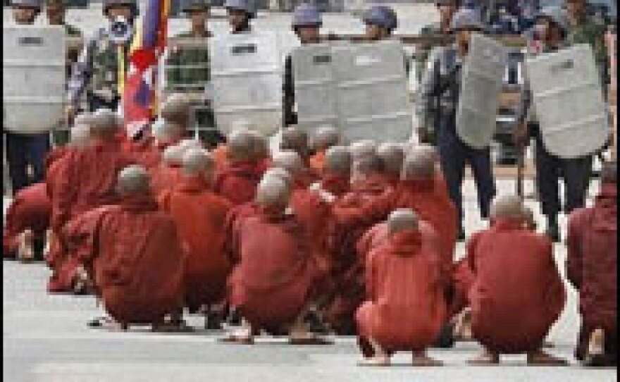 In a photo made available by <em>The Mandalay Gazette</em>, Buddhist monks pray at a riot police's road block in downtown Yangon, Myanmar, on Wednesday.