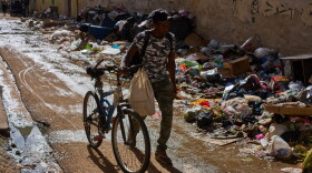 A man pushes his bicycle along a trash-strewn street in Havana, Cuba, Tuesday, June 9, 2026.
