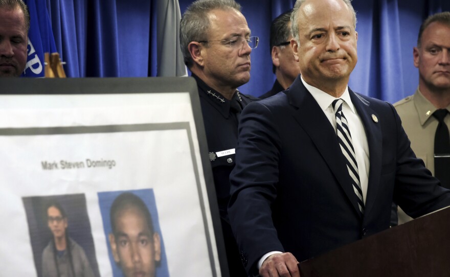 U.S. Attorney Nick Hanna stands next to photos of Mark Steven Domingo during a news conference in Los Angeles on Monday. Federal prosecutors said Domingo had planned to bomb a white supremacist rally as retribution for the New Zealand mosque attacks but was thwarted.