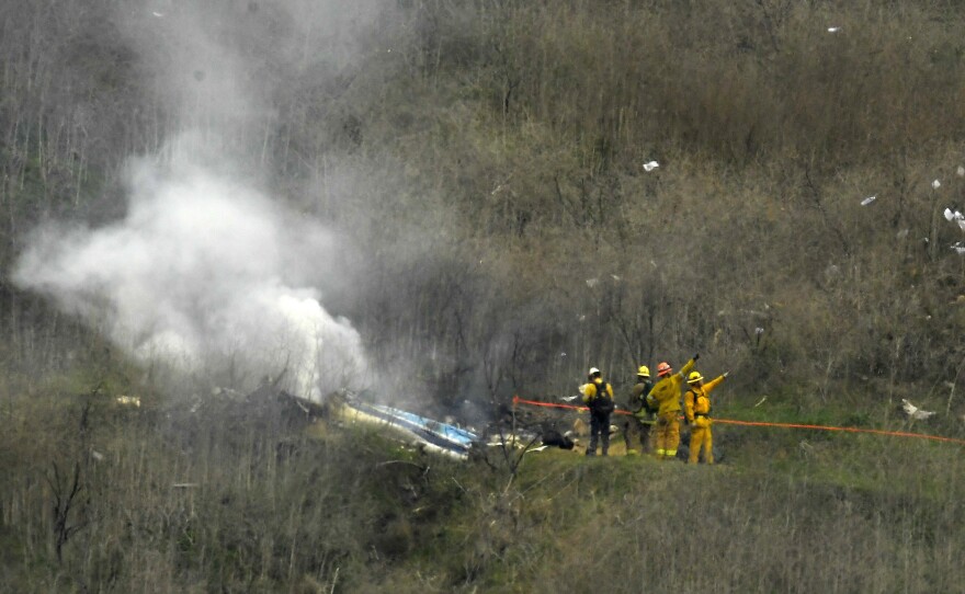 Firefighters work the scene of a helicopter crash where former NBA basketball star Kobe Bryant died in Calabasas, Calif., on Jan. 26, 2020. Bryant's widow is taking her lawsuit against the Los Angeles County Sheriff's Department and Fire Department to a federal jury seeking compensation for photos deputies shared of the remains of the NBA star, his daughter and seven others who died in the crash.