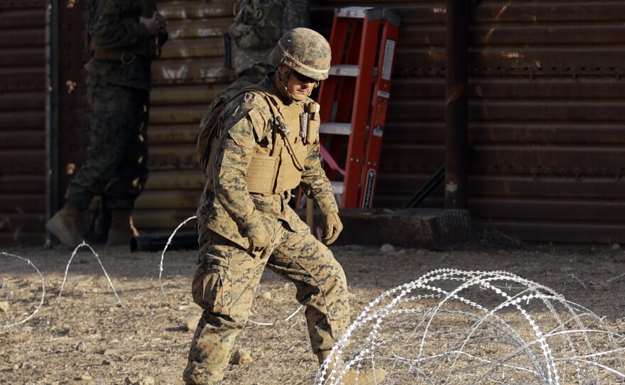 A Marine uses concertina wire to fortify the border separating Tijuana, Mexico, and San Diego, near the San Ysidro Port of Entry.