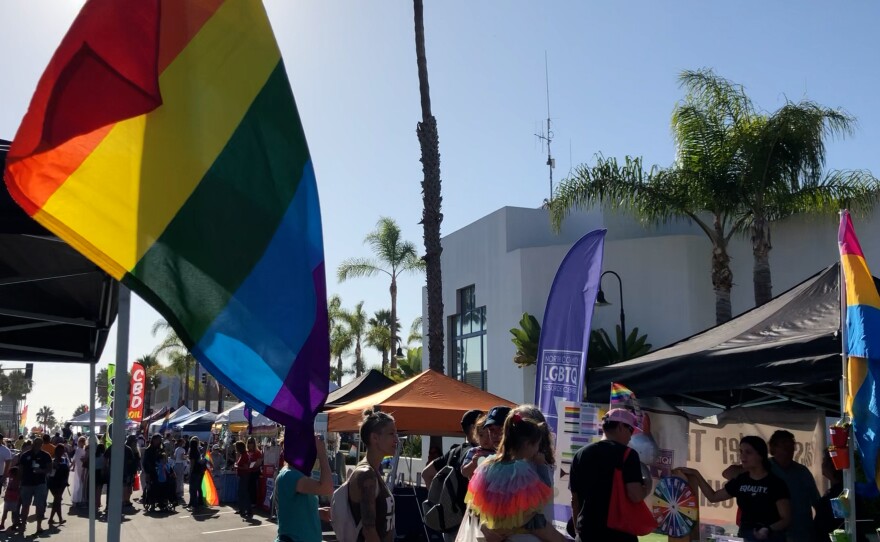Pictured a pride flag and booths at the 2019 Pride by the Beach event in Oceanside, Calif.