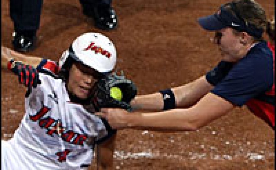 Japan's Masumi Mishina is tagged out at by Monica Abbott during the women's gold medal softball game at the Fengtai Softball Field on Thursday.