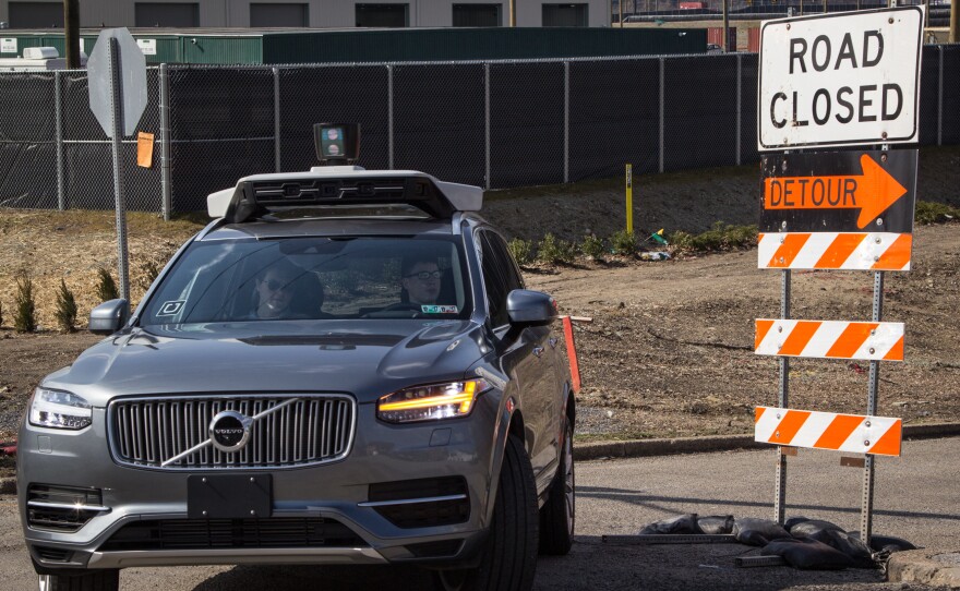 In Pittsburgh, where Uber is testing self-driving cars, each autonomous vehicle has two employees in the front seat; one is ready to grab the wheel and apply a foot to the brake pedal, the other in the passenger seat, has a computer screen showing what the car's rooftop laser-bouncing radar is seeing.
