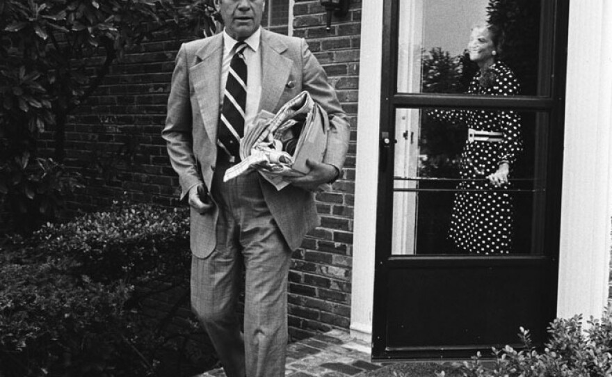 President Gerald Ford walks out of his house in Alexandria, Virginia with First Lady Betty Ford in the doorway on August 18, 1974, having concluded his first week in office.