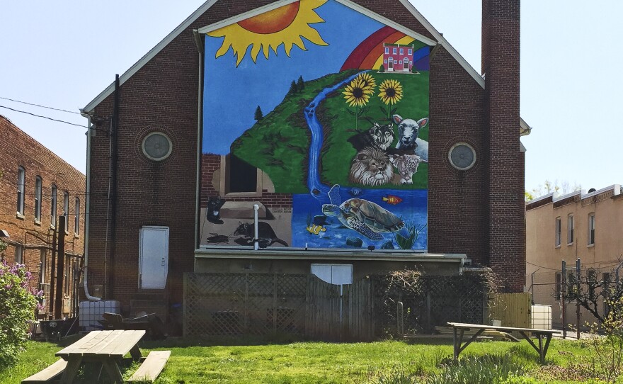 A large mural covers the back side of the Amazing Grace Lutheran Church in East Baltimore. It backs onto a park created by the Charm City Land Trust in an area where abandoned homes once stood.