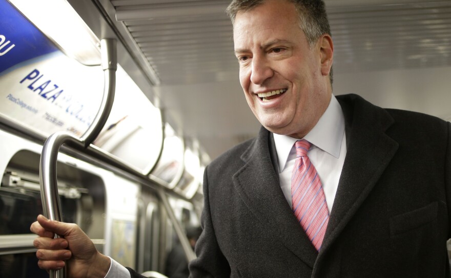 New York City mayoral candidate Bill de Blasio rides the subway while greeting commuters in New York on Monday.