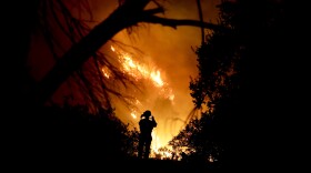 A firefighter takes a cell phone picture during a wildfire in Montecito, Calif., Saturday, Dec. 16, 2017. 