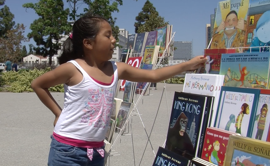 Kaily Gonzalez picks up a copy of "El Libro del Osito," Aug. 29, 2015.