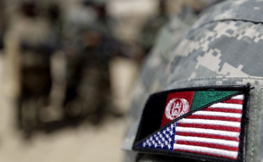 An Afghan interpreter working with the 101st Airborne Division displays a patch showing the Afghan and U.S. flags.