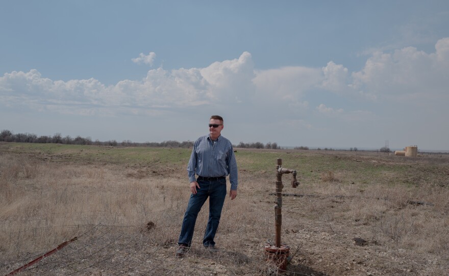 Dan Arthur, the president and chief engineer of ALL Consulting, stands beside a defunct oil well in the Tallgrass Prairie Preserve in Oklahoma on March 20, 2024. The well has not been used for years — there's no pump attached to it. But it hasn't been properly plugged, either.