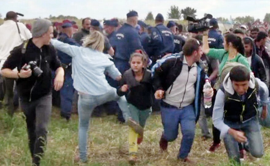 A screengrab shows a Hungarian TV camerawoman kicking a child running with other migrants from a police line during disturbances at Roszke, southern Hungary, in 2015. After the footage appeared, the camerawomen was fired. She has been sentenced to three years' probation.