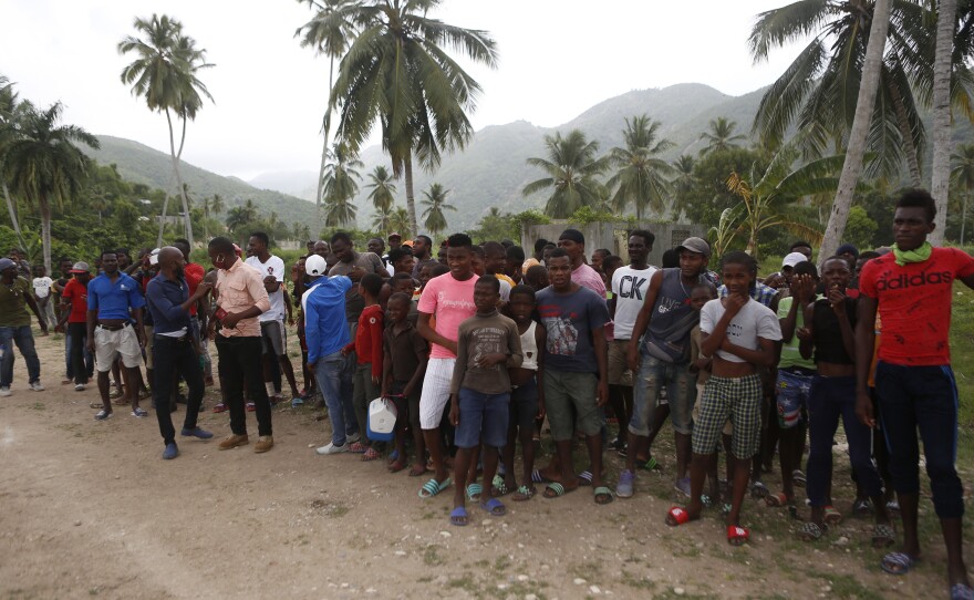 Families wait to receive humanitarian aid from a U.S. Army helicopter unit in the town of Baradères, Haiti, on Wednesday.