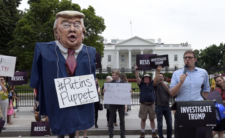 People gather outside the White House on Pennsylvania Avenue in Washington on Tuesday, July 11, 2017, to protest President Donald Trump.