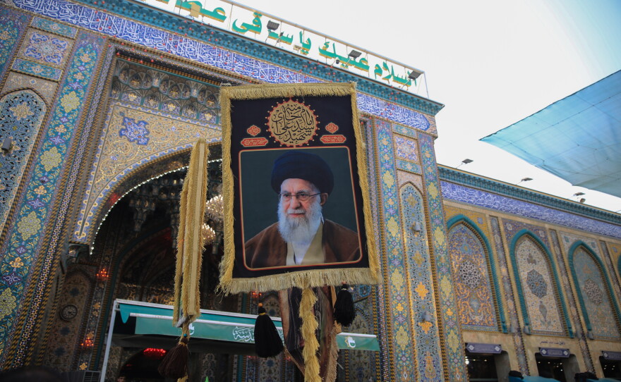 Pilgrim carries a portrait of Iran's Supreme Leader, Ali Khamenei, outside the Imam Hussein Shrine in Karbala during the Arbaeen pilgrimage.