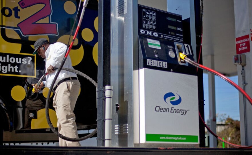 Bob Davis fills up his airport shuttle van at a natural gas pumping station in College Park, Ga. A growing number of companies are considering converting their vehicle fleets to natural gas.