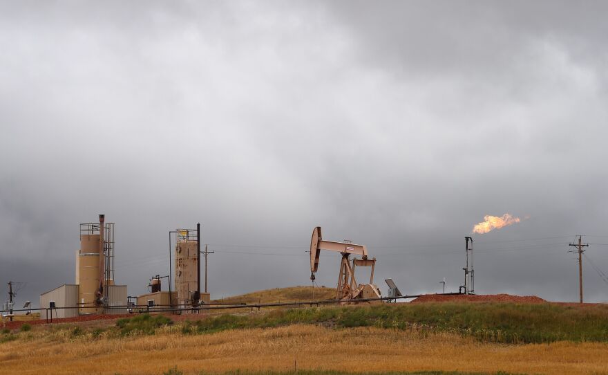 Pump jacks and a gas flare are seen near Williston, N.D., in 2016.