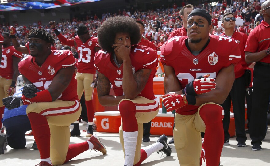 From left, Eli Harold (58),  Colin Kaepernick (7) and Eric Reid (35) kneel during the national anthem before their NFL game against the Dallas Cowboys on Sunday, Oct. 2, 2016.
