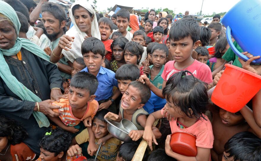 Rohingya Muslim refugees wait to receive food distributed from a Turkish aid agency at Thaingkhali refugee camp in Ukhia, Bangladesh on Saturday.