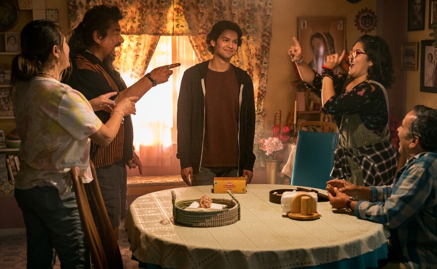 Elpidia Carrillo as Rocio, George Lopez as Uncle Rudy, Xolo Maridueña as Jaime Reyes, Belissa Escobedo as Milagro and Damian Alcazar as Alberto in “Blue Beetle.” A Warner Bros. Pictures release.