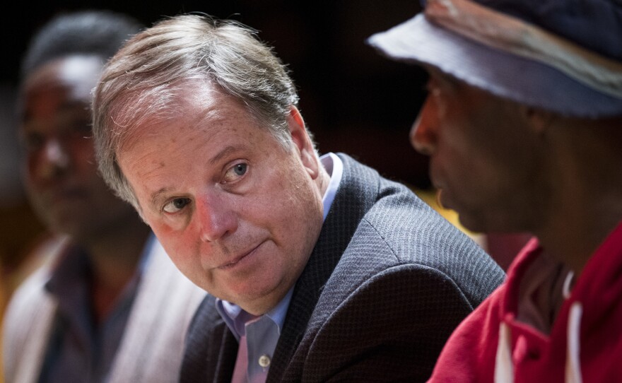 Doug Jones, Democratic candidate for the Senate, meets with voters at a Mexican restaurant in Talladega, Ala.