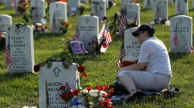 Denise Hlavaty leans on the head stone of her boyfriend Army Staff Sergeant Steve Butcher, Jr., of Rochester, New York, on Memorial Day May 30, 2011 at Arlington National Cemetery in Arlington, Virginia. Butcher died May 23, 2007 of wounds from an IED attack while he was serving in Ramadi, Iraq.