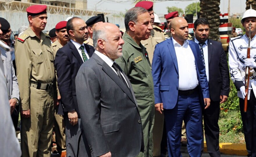 Iraqi Prime Minister Haider al-Abadi (center) attends a funeral for two generals killed in fighting with Islamic State militants in Ramadi, west of Baghdad, in August. In an interview Monday with NPR, the Iraqi leader called on the U.S. to provide more airstrikes but said his country does not want ground forces from the U.S. or any other country.