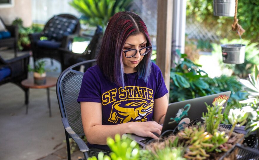 San Francisco State University student Marissa Ledesma works on her computer in the backyard of her home in Bakersfield on Oct. 27, 2021.