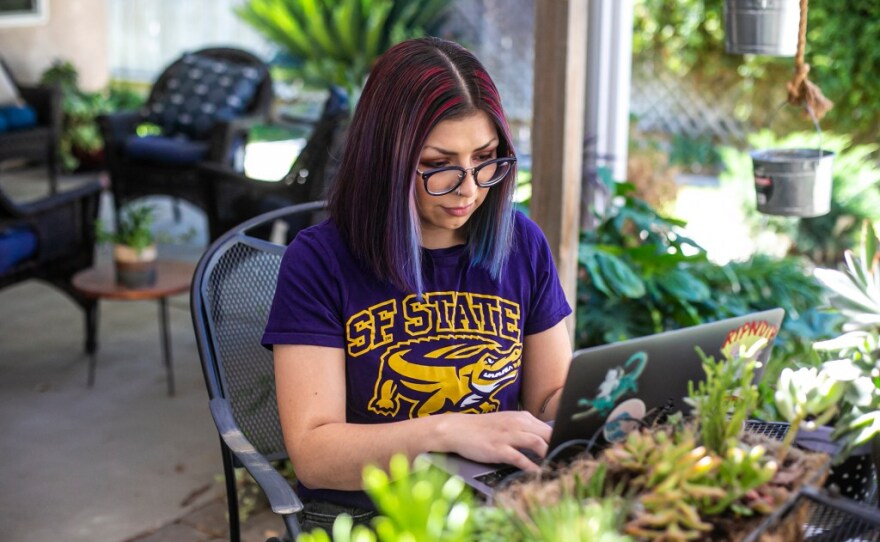 San Francisco State University student Marissa Ledesma works on her computer in the backyard of her home in Bakersfield on Oct. 27, 2021. 