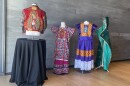 Works from the Mingei's "Fashioning an Icon" exhibit are shown on March 24, 2025. Local artist and fashion designer Claudia Rodríguez-Biezunski's jacket is shown at left. Local artist Diana Benavídez's green, piñata-style cape is shown on the far right.