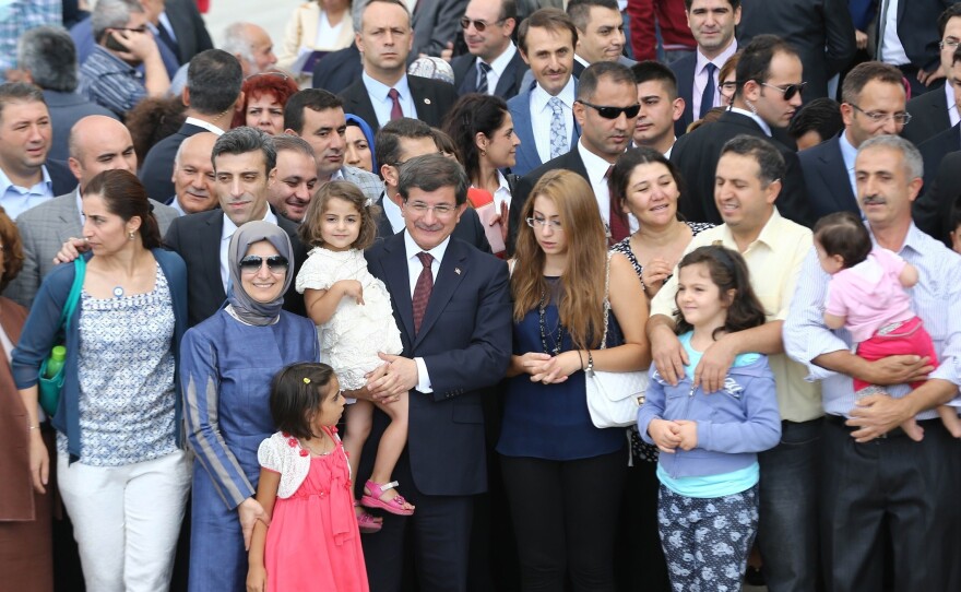 Prime Minister Ahmet Davutoglu, center, poses with dozens of freed Turkish hostages at the Esenboga Airport in Ankara Saturday. The group was held by militants in northern Iraq for more than three months.