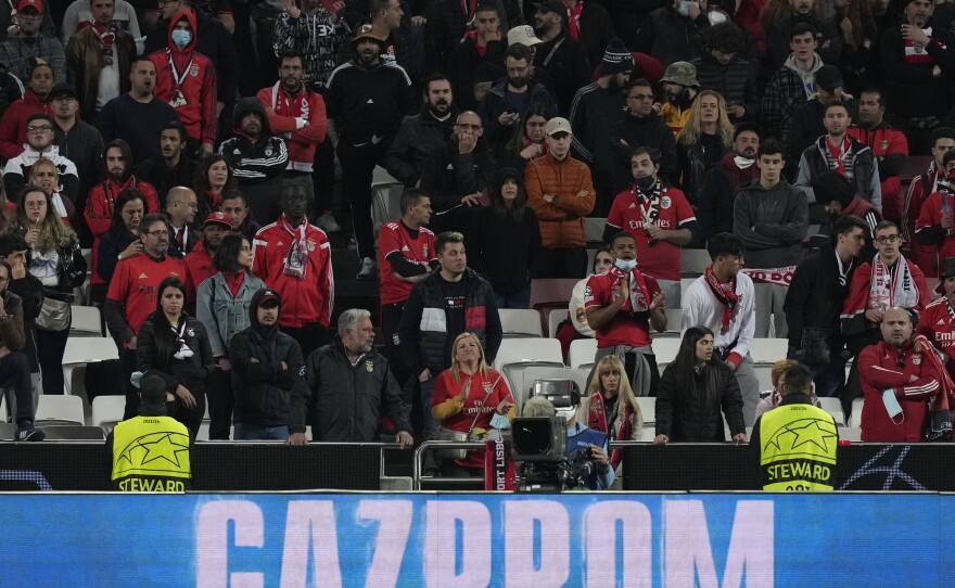 The Russian state-owned gas company Gazprom is displayed on an advertising board as Benfica fans attend a Champions League soccer match between Benfica and Ajax in Lisbon.