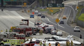 Emergency responders gather round the crash of a Cessna 310 aircraft on Interstate 405, just short of a runway at John Wayne Airport in Costa Mesa, Calif Friday, June 30, 2017.