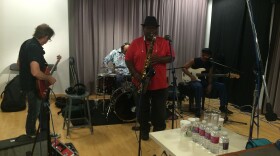 From left to right, Johnny Vernazza tunes guitar, sax player Walter Gentry (center), Len Rainey (far right) Edward Cleveland sits behind drum set at KPBS, April, 30, 2015. 

