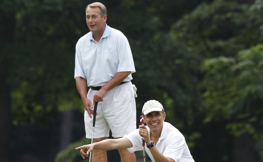 President Obama points to Vice President Biden's putt as they and House Speaker John Boehner, R-Ohio, golf at Andrews Air Force Base, Md., in June 2011.