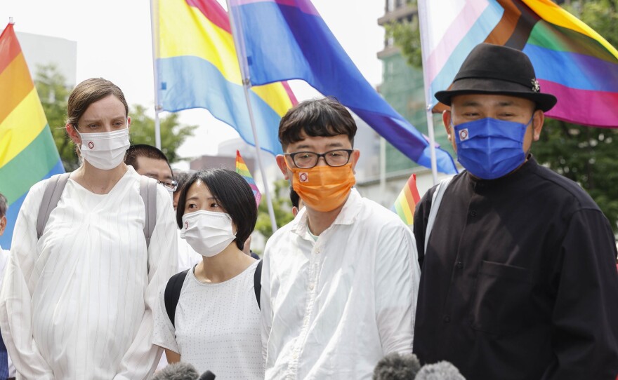 Plaintiffs speak to journalists after a court ruling in Osaka, western Japan Monday, June 20, 2022.