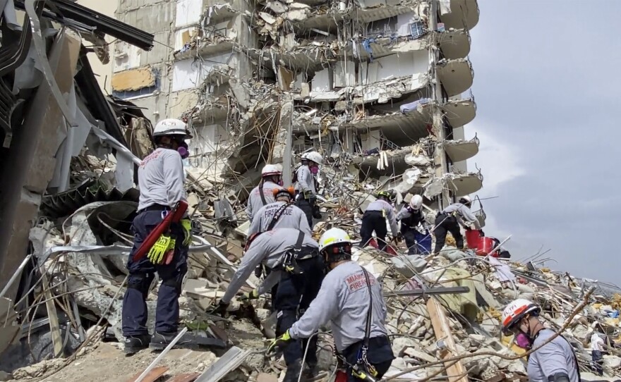 In this photo provided by Miami-Dade Fire Rescue, search and rescue personnel search for survivors through the rubble at the Champlain Towers South Condo in Surfside, Fla., on Friday.