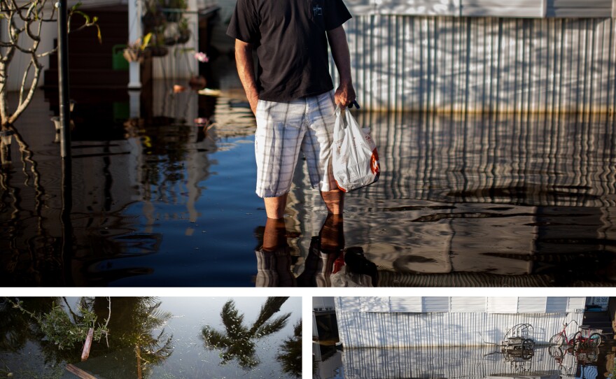 Gary van Gorp carries food home through floodwaters in his neighborhood in Fort Myers, Fla. The waters remained for six days after Hurricane Irma hit.