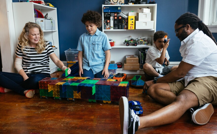 Allyson Ward and her husband, Marcus Ward, play with their twin sons, Milo and Theo, both 10. The family's debt reached $80,000 following years of care for the boys.
