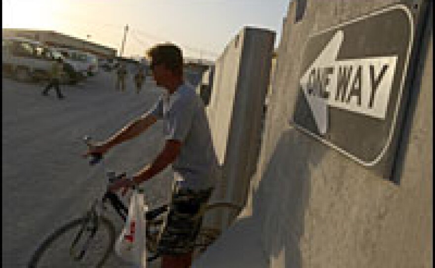 NATO forces and civilian contractors mix on the base. Despite attempts to make life as normal as possible, heavy concrete blast walls are necessary for this working military base.